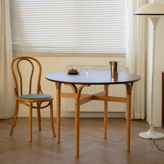 a solid wood round dining table with a dining chair