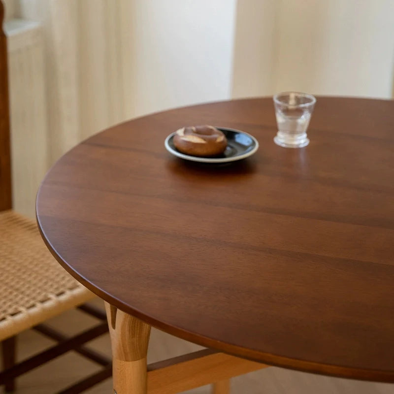 a round wood dining table for 4, showing the smooth wooden table-top