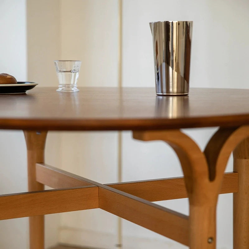 a round wood dining table for 4, showing the intricate wood carvings