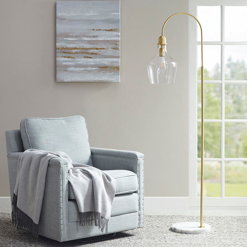 Modern arc floor lamp in gold with glass bell-shaped lamp shade and white marble base