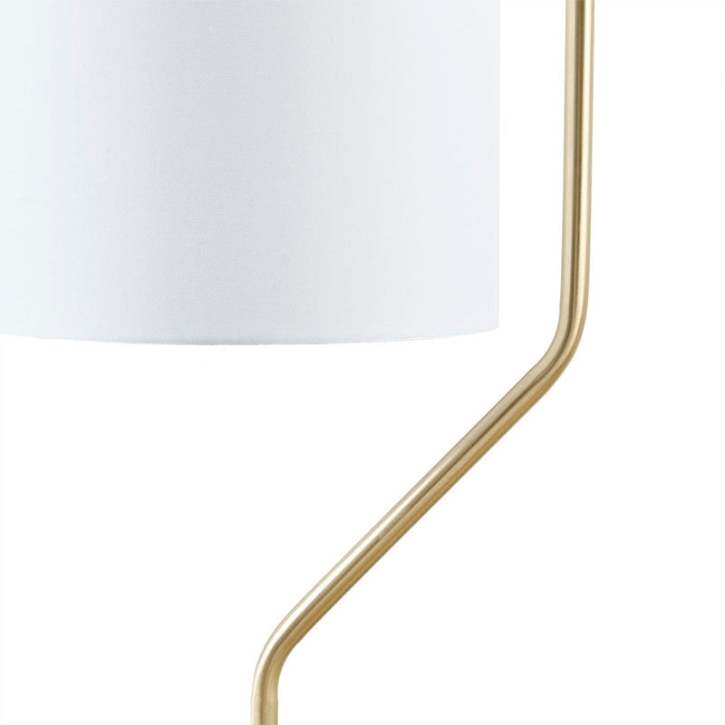 the white drum-shaped shade of a modern floor lamp