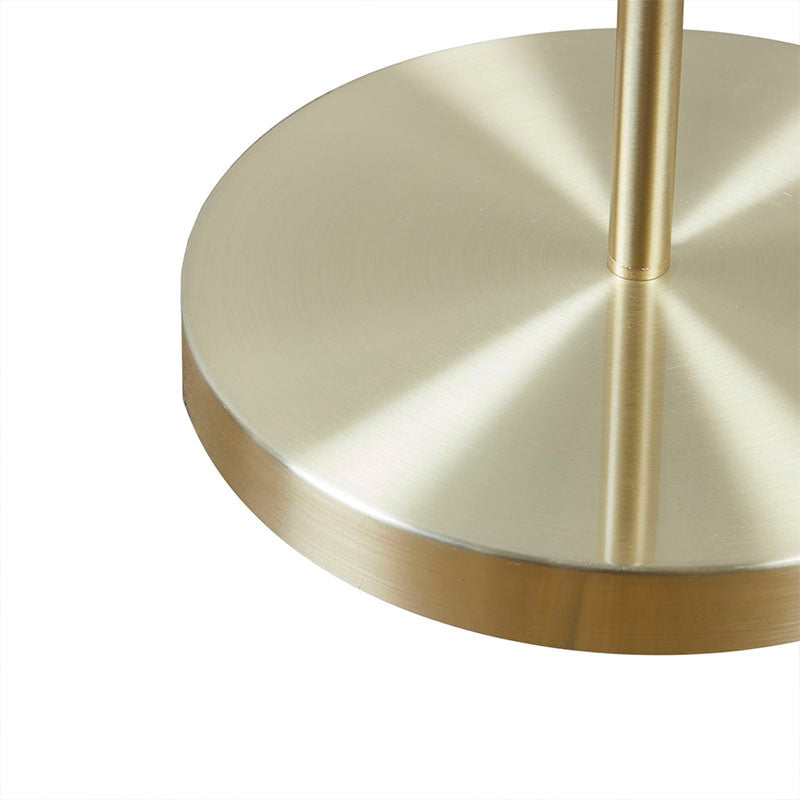 the gold base of a modern floor lamp