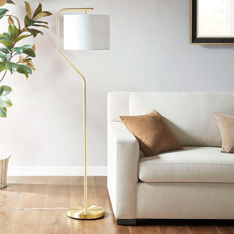 a modern gold floor lamp with drum-shaped shade in a chic living room