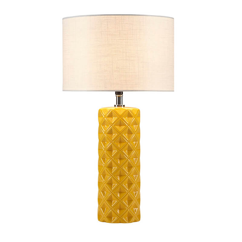 an illuminated ceramic table lamp in a white background