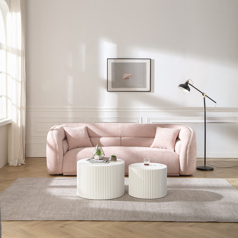 Pink sofa with two white end table and  lighting with a wall art 